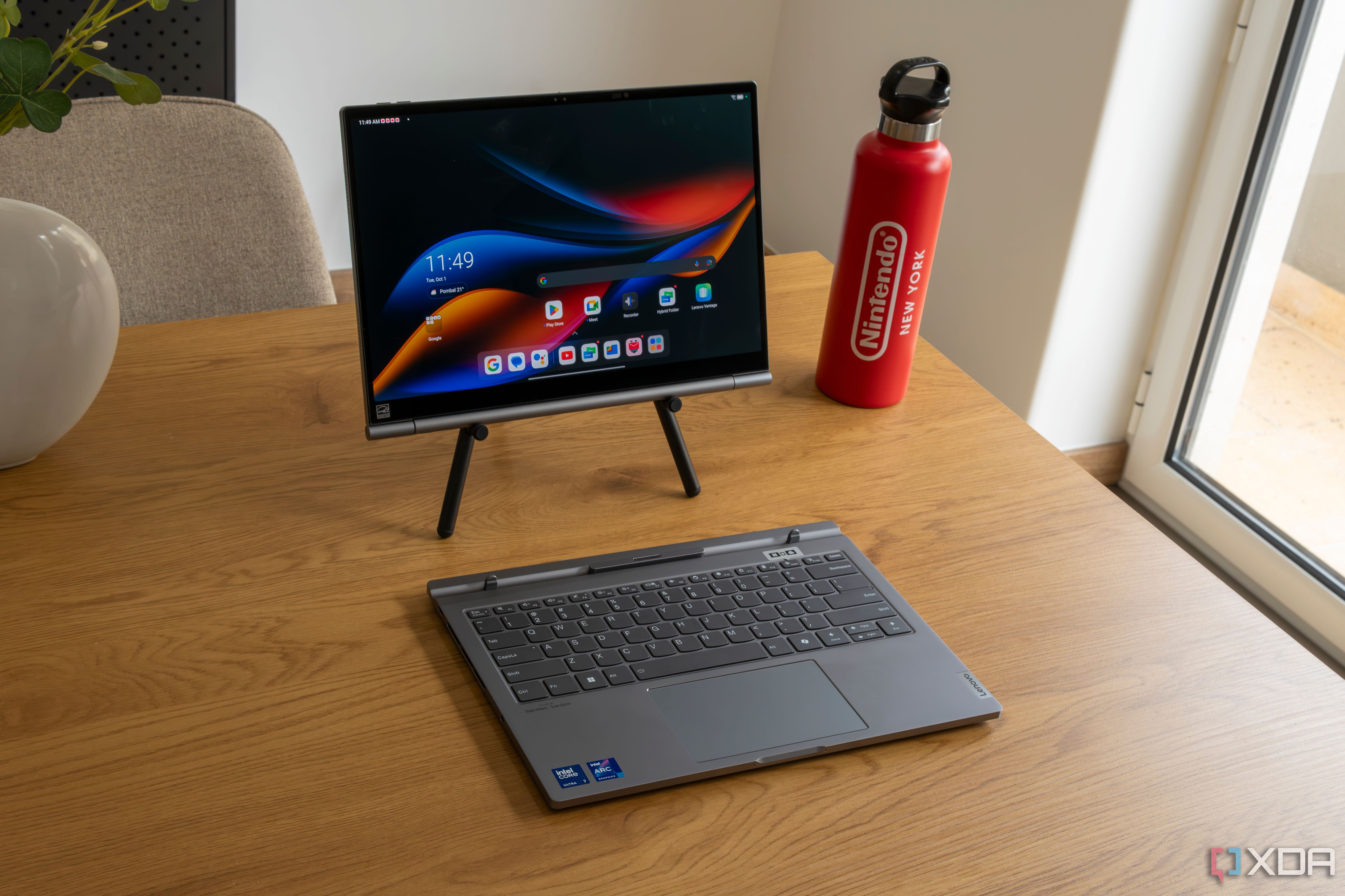 A Lenovo ThinkBook Blus Gen 5 Hybrid Station on a wooden table next to a Hybrid Tab resting on the included stand