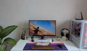 A PC setup showing a PC, monitor, and desk with accessories