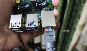 A person holding a Radxa X4, with an Ethernet cable plugged into the SBC
