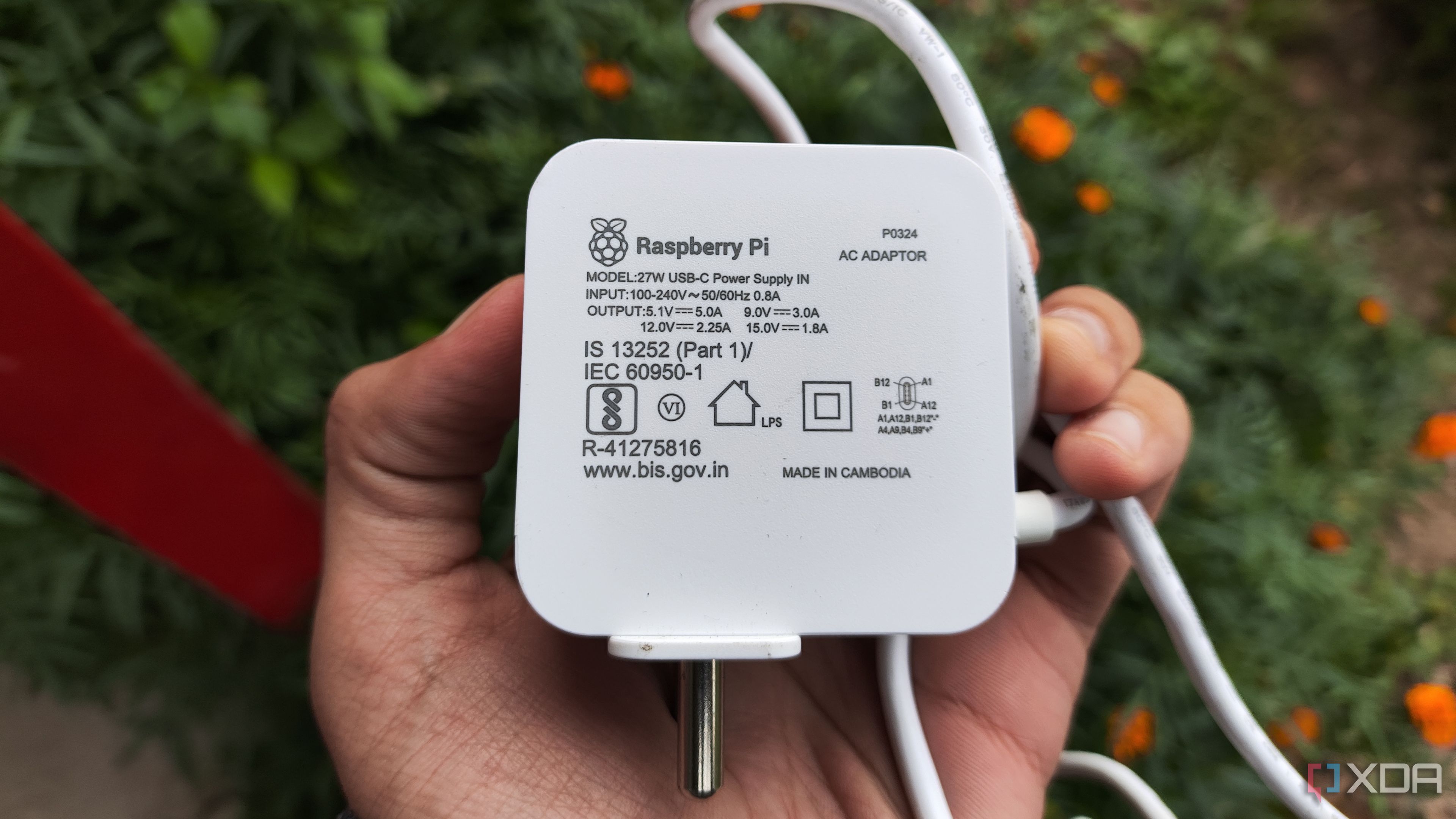 A person holding a Raspberry Pi power supply