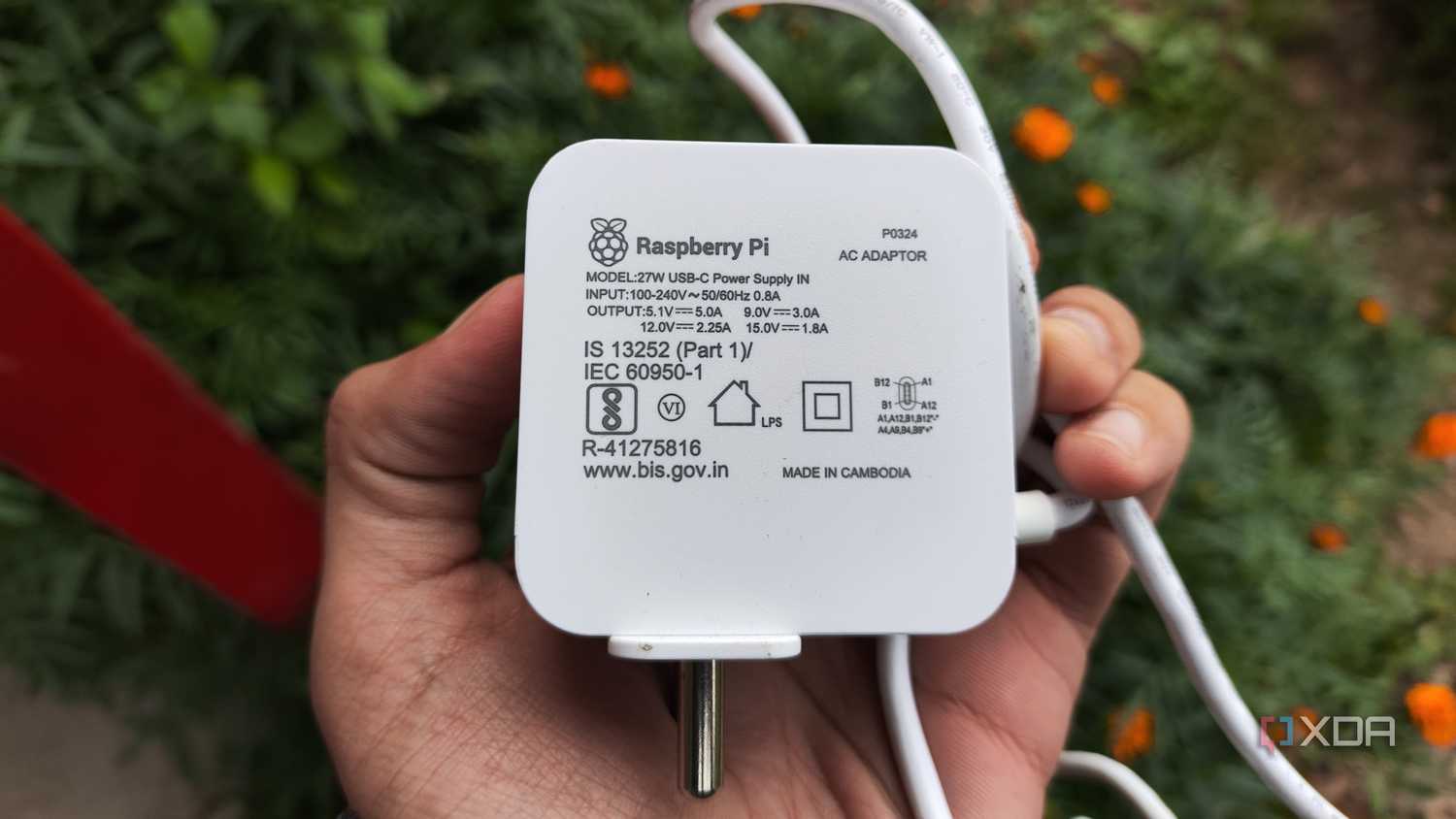 A person holding a Raspberry Pi power supply