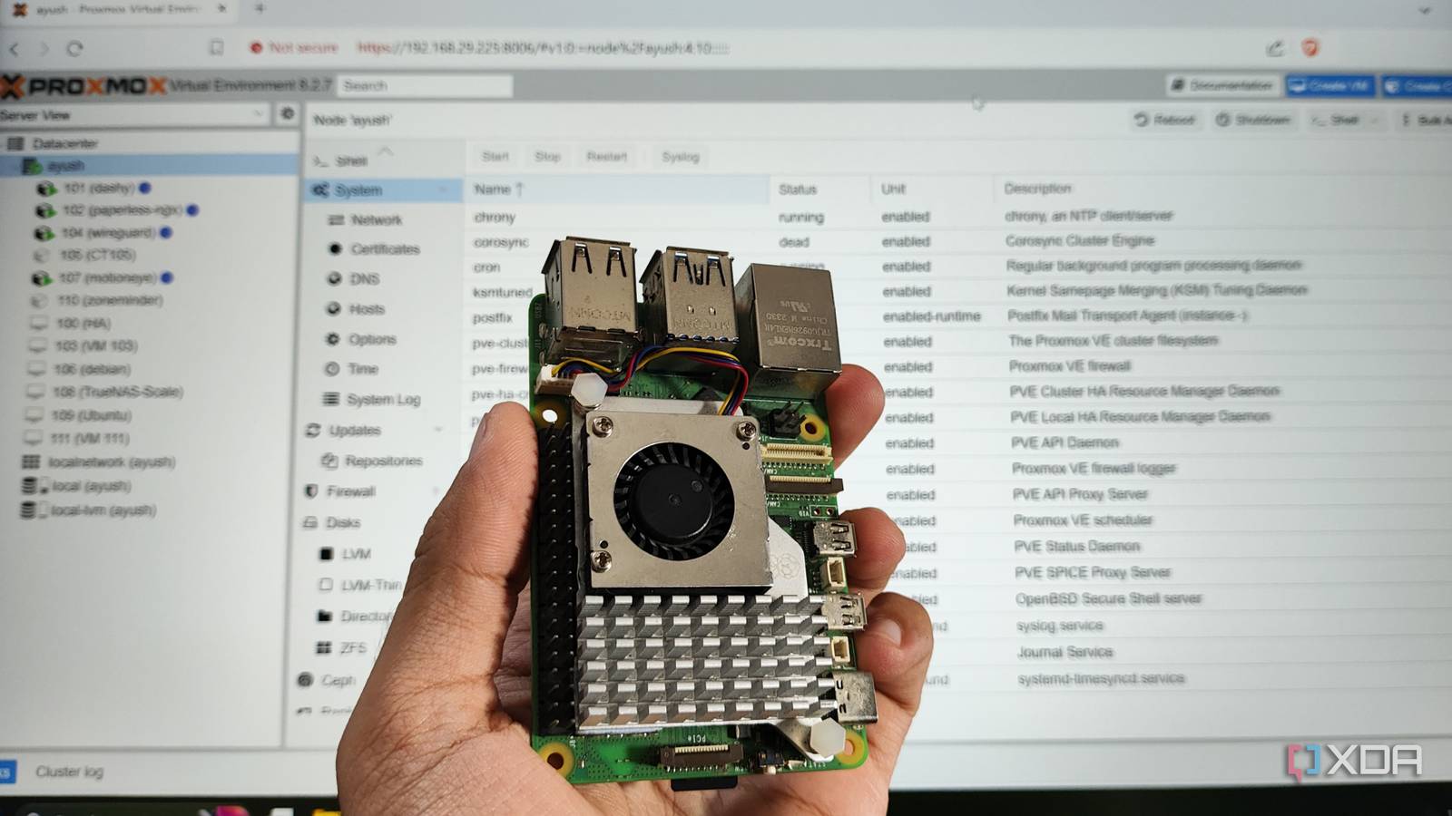 A person holding a Raspberry Pi in front of a PC