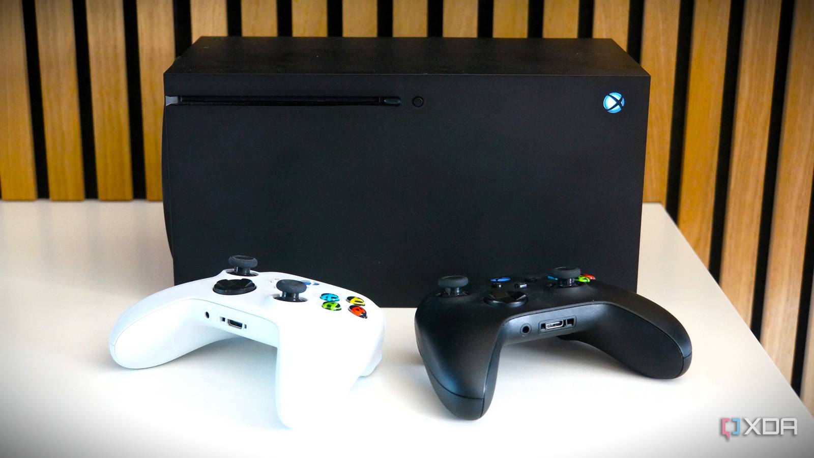 xbox series x with two controllers in front of it