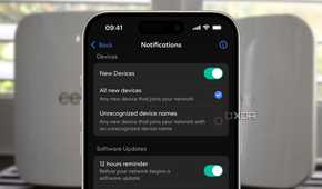 eero app showing new device notification setting over a blurred background of two white routers
