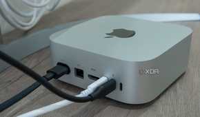 Angled rear view of the M4 Mac Mini with cables plugged into some of the ports