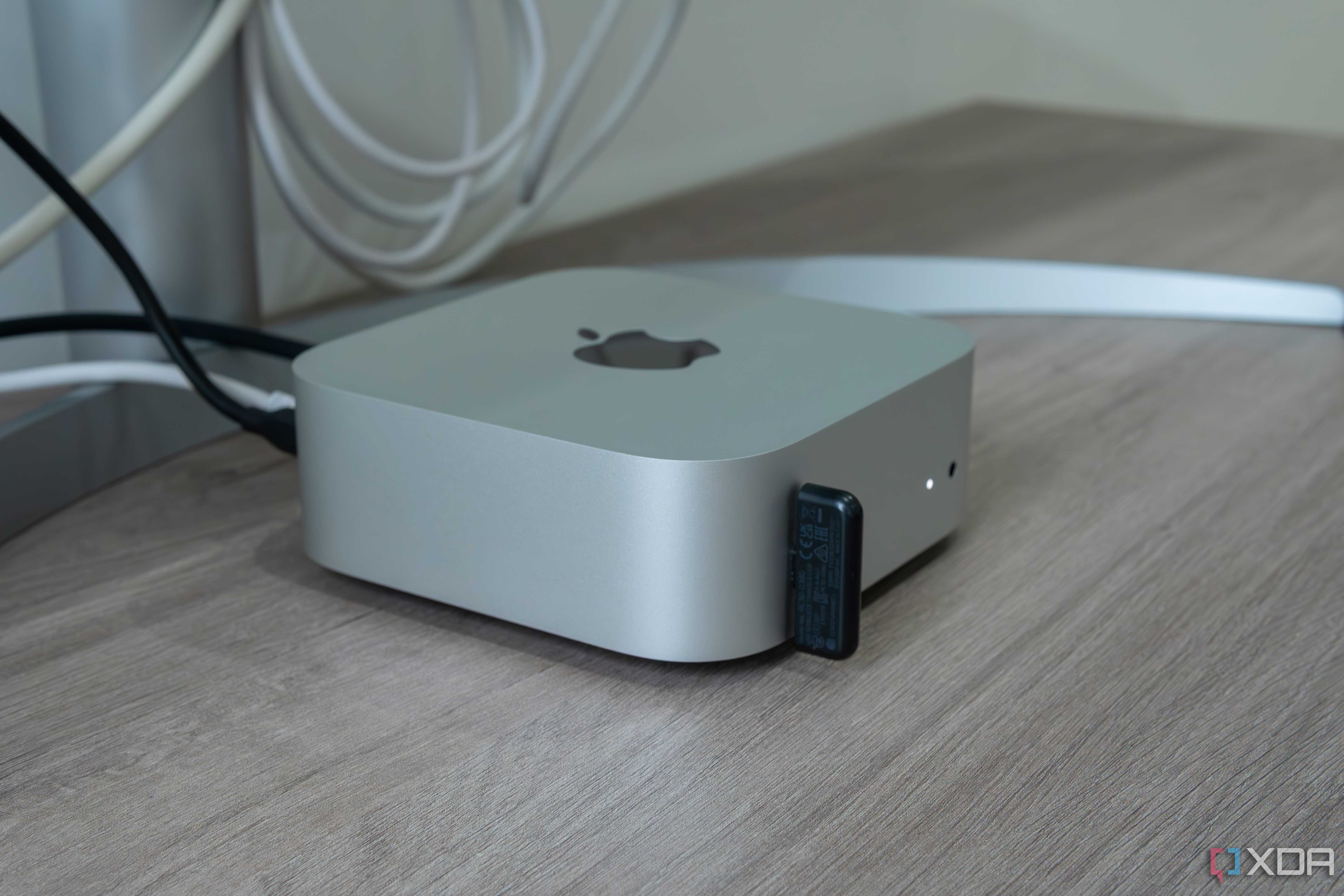 Side view of the M4 Mac Mini with a USB dongle plugged into one of the ports on the front