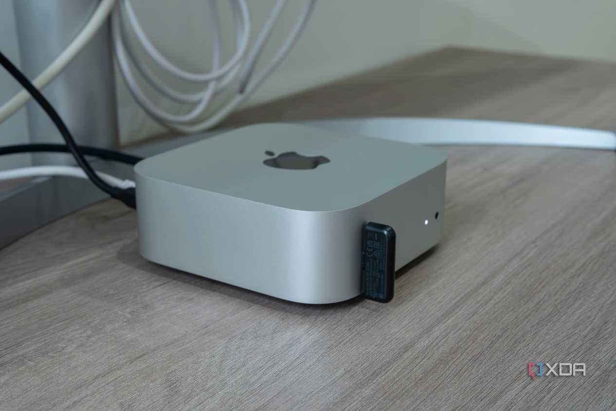 Side view of the M4 Mac Mini with a USB dongle plugged into one of the ports on the front