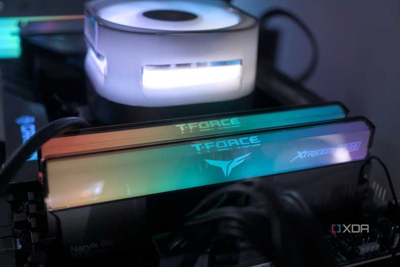 An image of RGB RAM modules installed on a motherboard across a CPU fan.