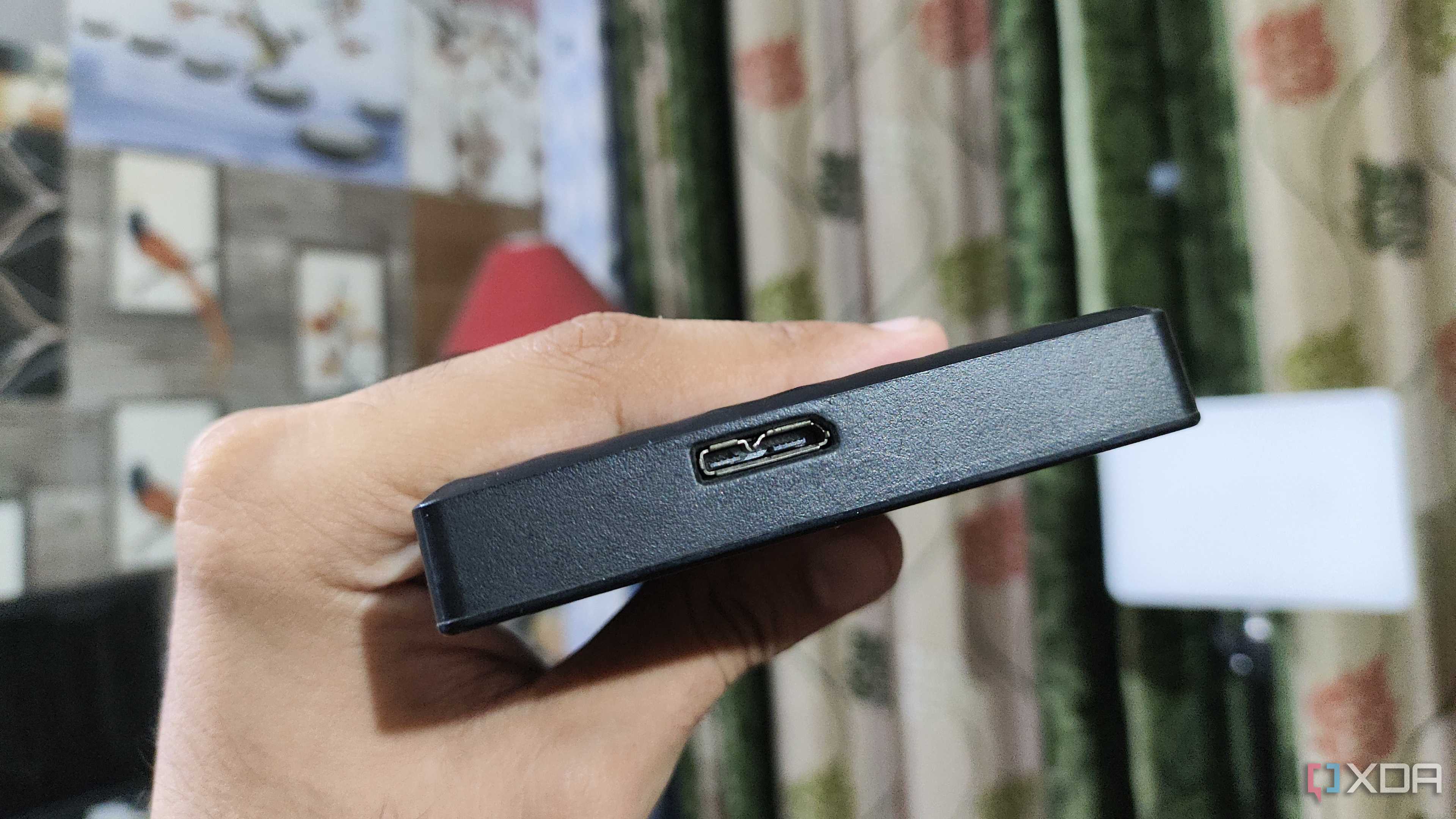 A person holding an external HDD