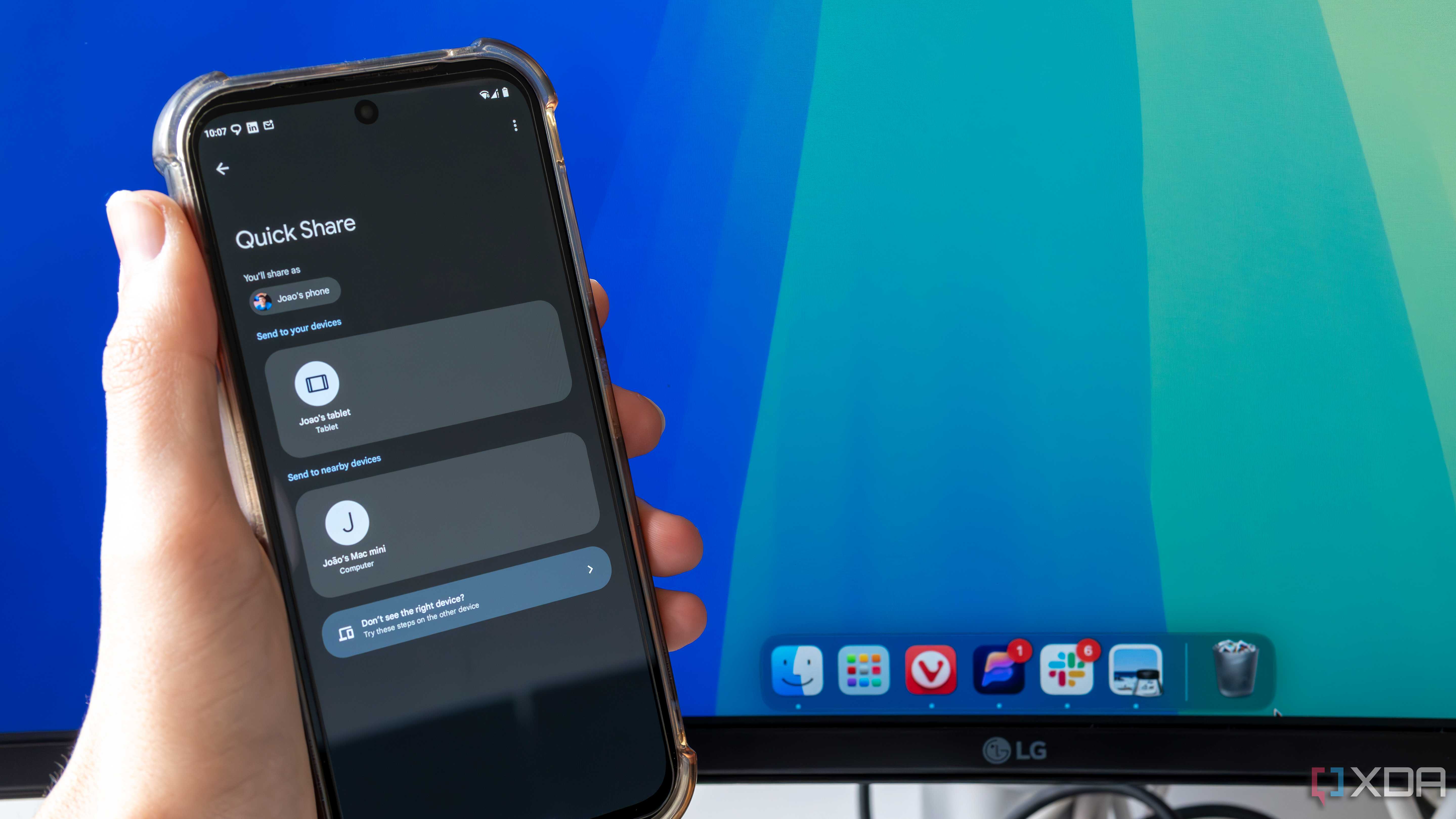 An Android phone trying to share a file using Quick Share with a Mac desktop in the background. The phone shows a Mac Mini as an available sharing target