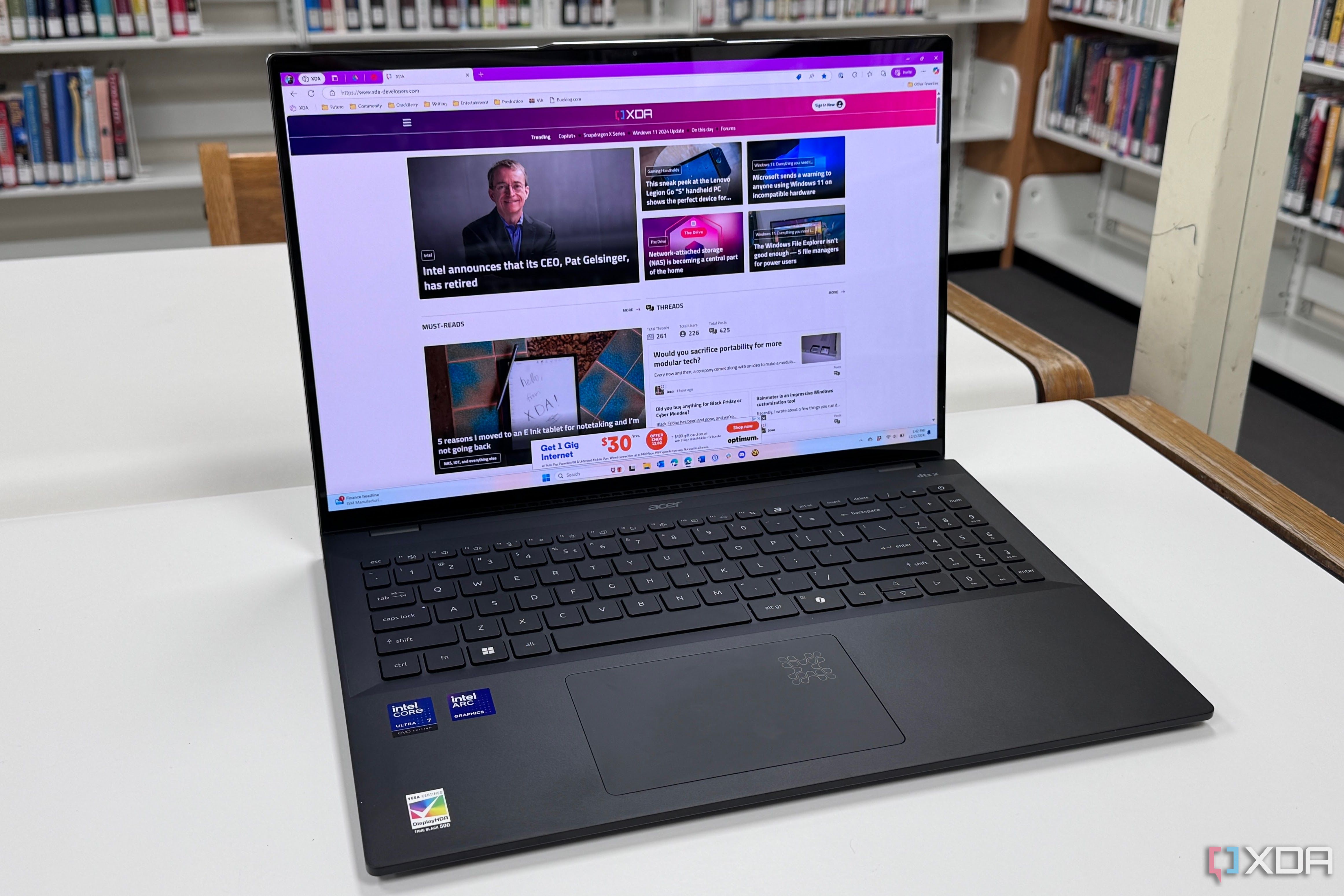 The Acer Swift 16 AI sitting on a white table with bookshelves in the background