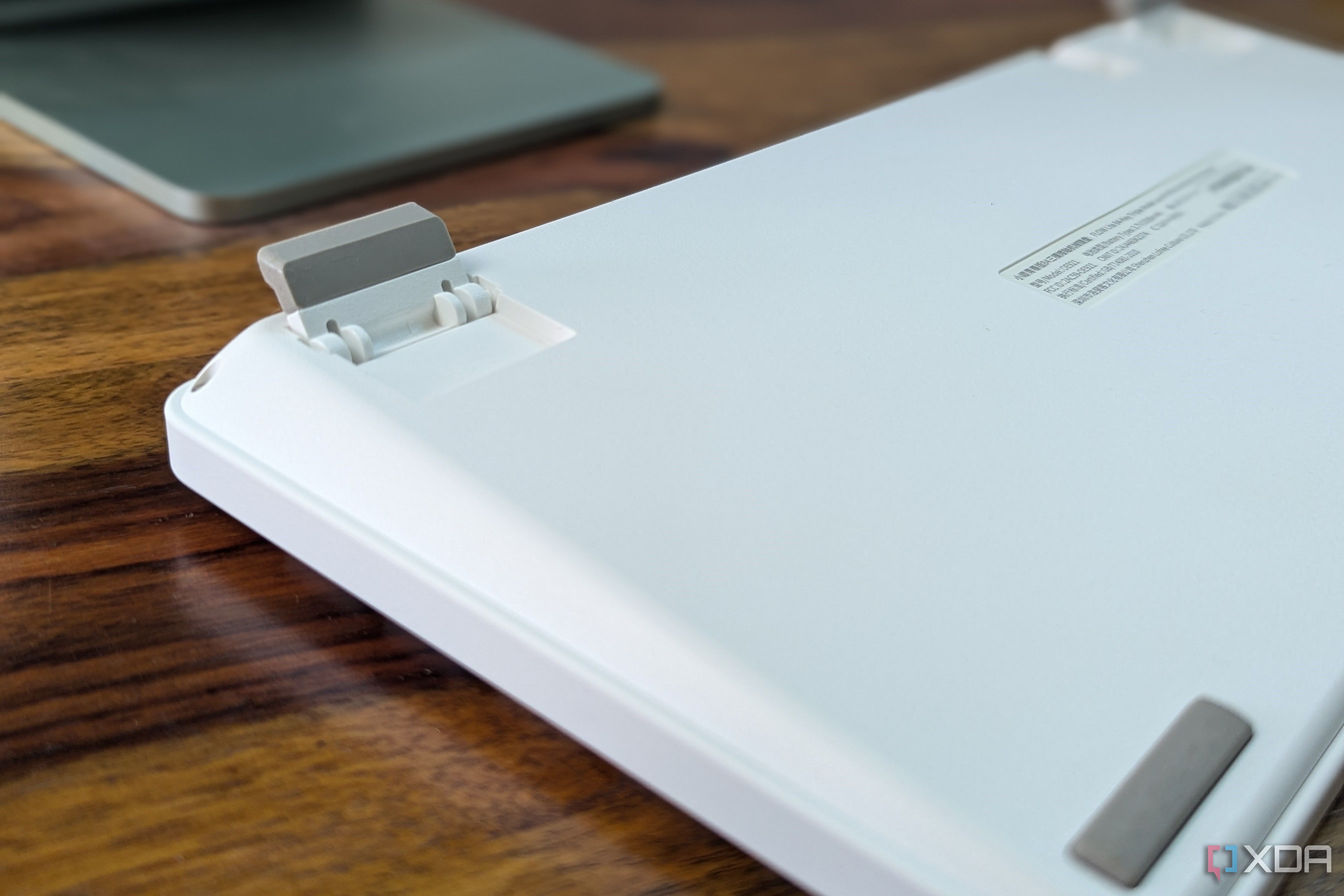Close-up of a white low-profile mechanical keyboard showing kickstands