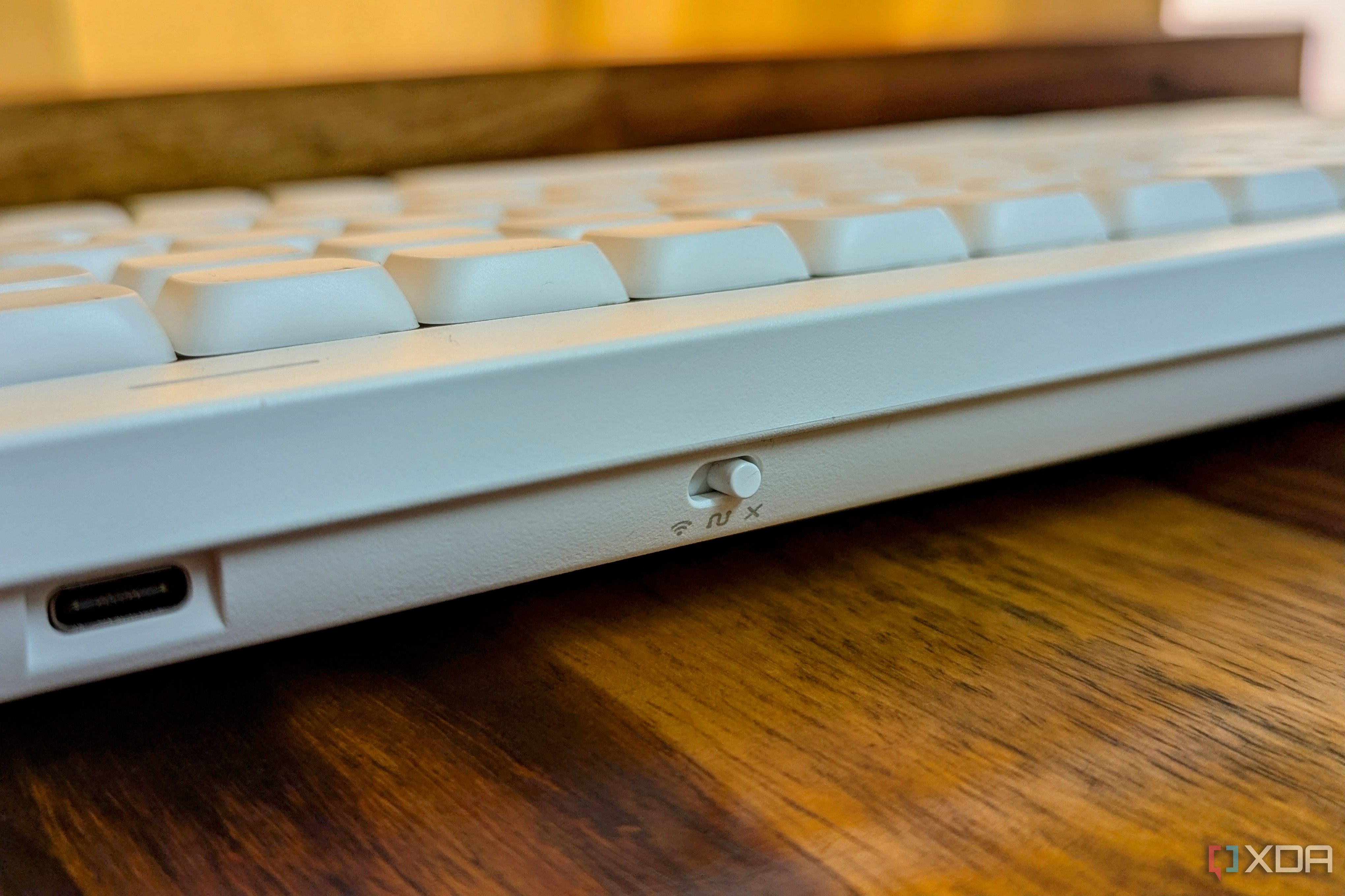 Close-up of a white low-profile mechanical keyboard showing wireless modes