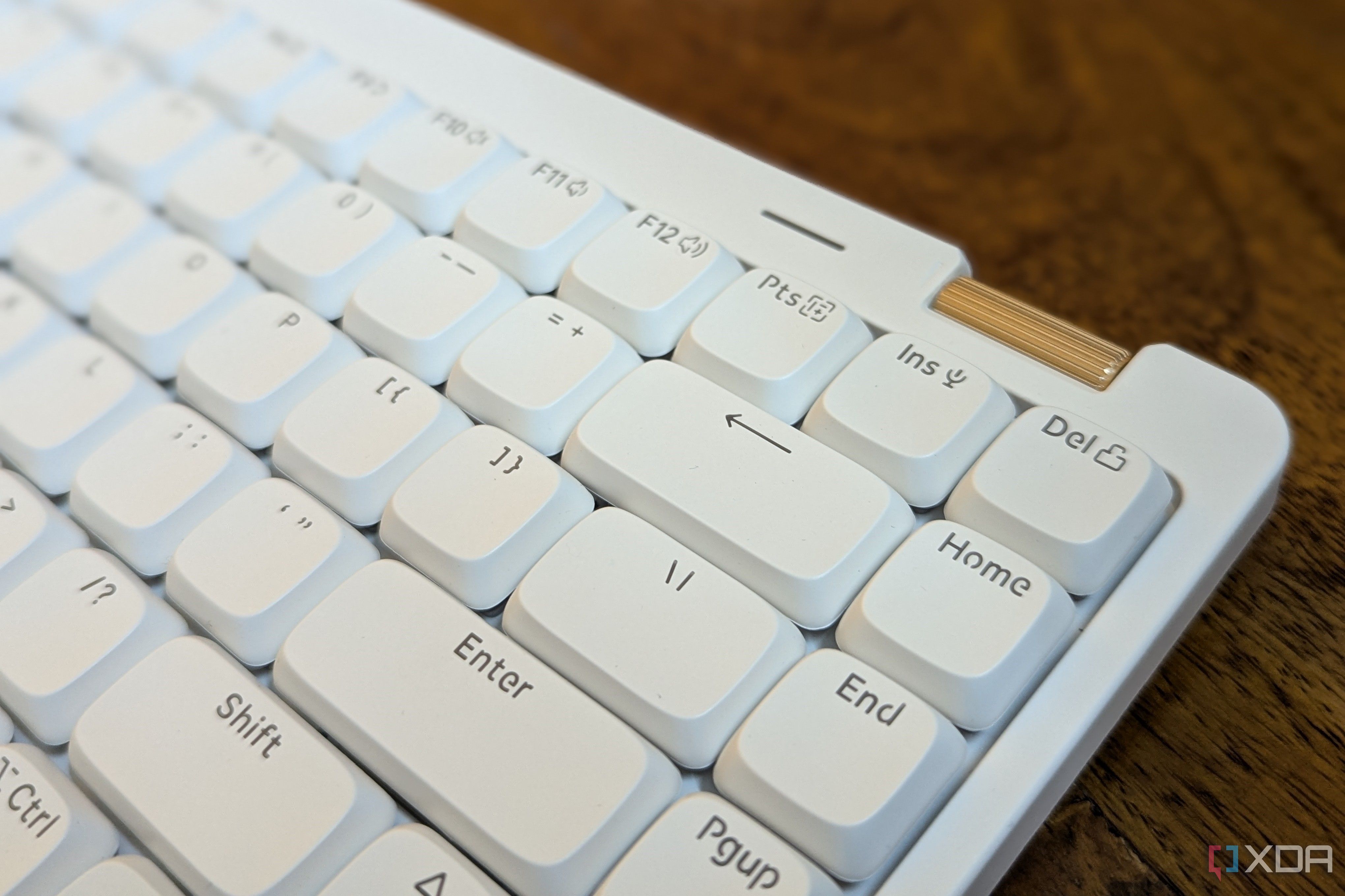 Close-up of a white low-profile mechanical keyboard showing a volume wheel