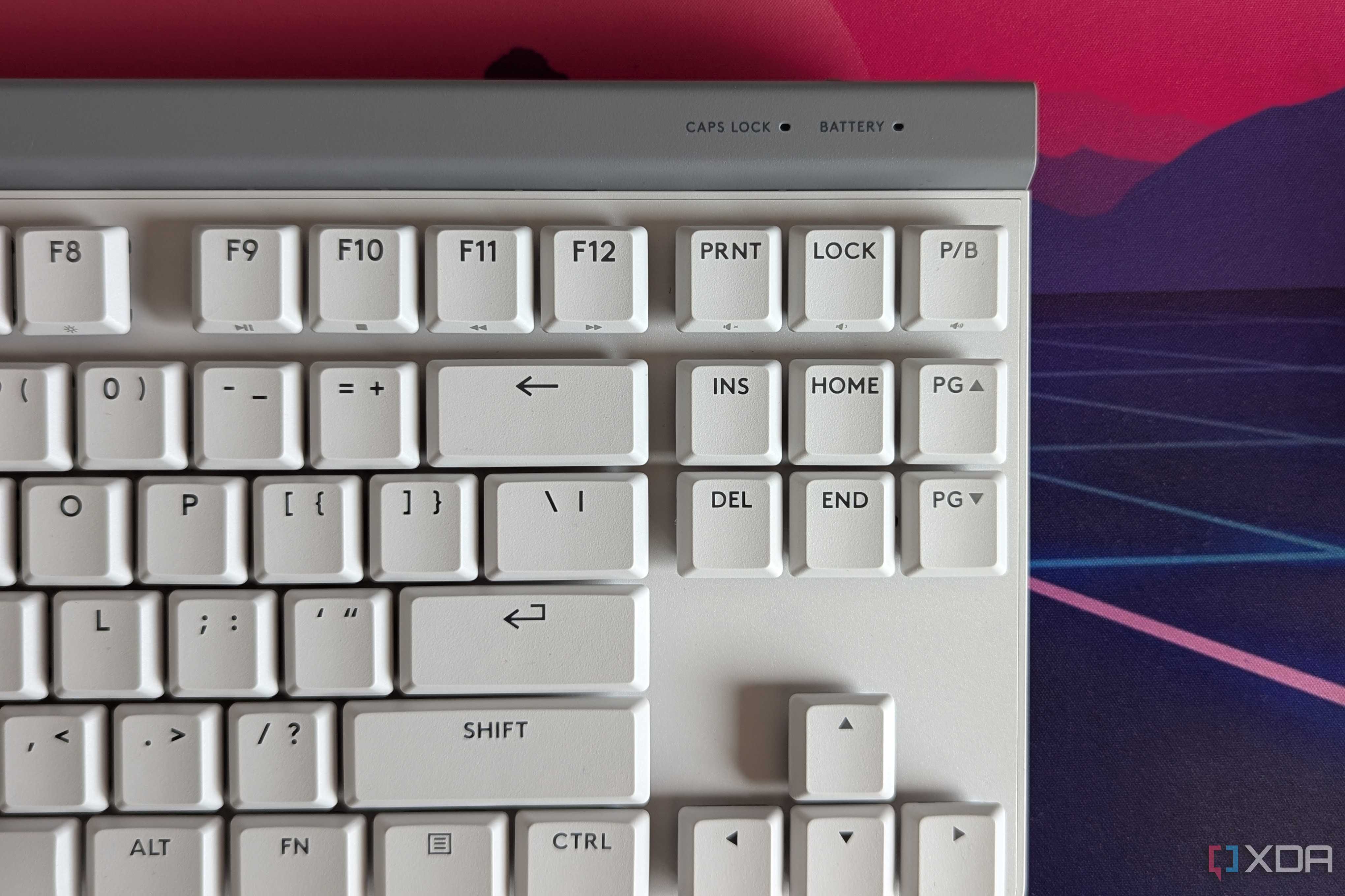Close-up of a white mechanical keyboard showing battery indicator light