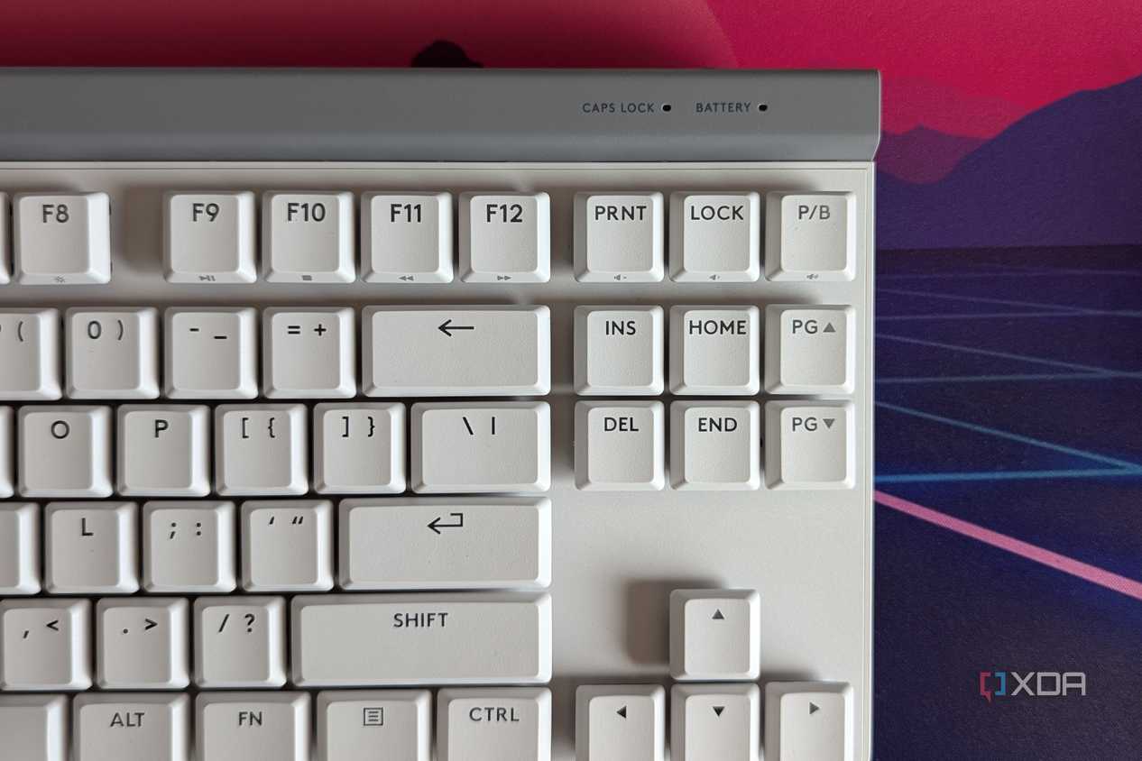 Close-up of a white mechanical keyboard showing battery indicator light