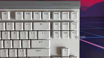 Close-up of a white mechanical keyboard showing battery indicator light