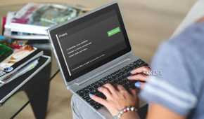 person using a laptop with FFmpeg download page on screen
