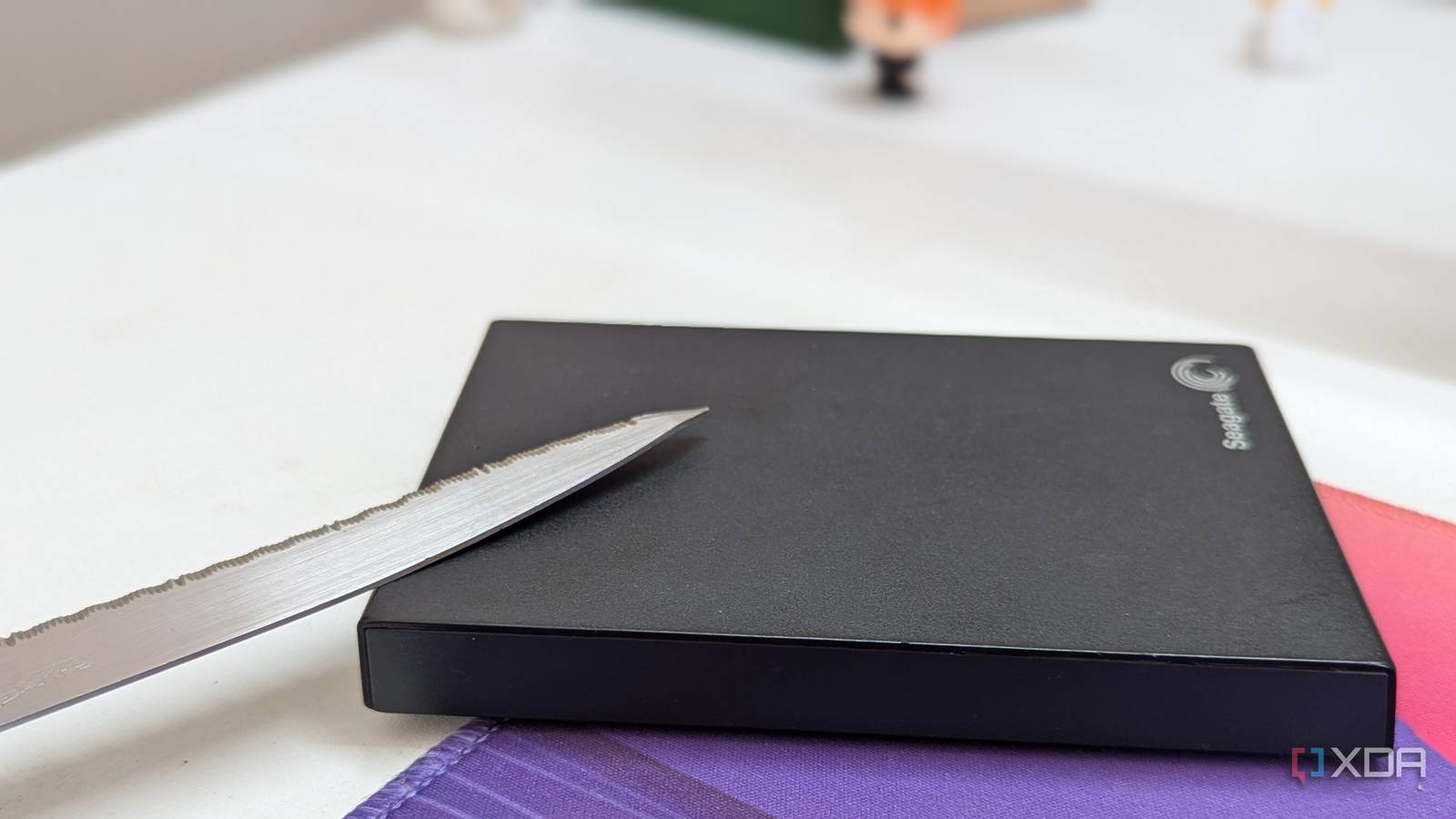 A black external hard drive with a metal blade on a desk
