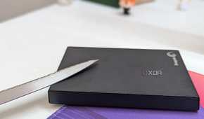 A black external hard drive with a metal blade on a desk