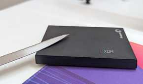 A black external hard drive with a metal blade on a desk
