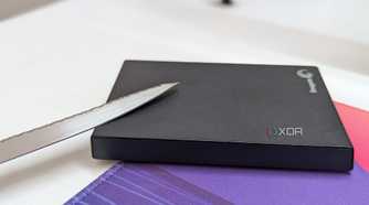 A black external hard drive with a metal blade on a desk
