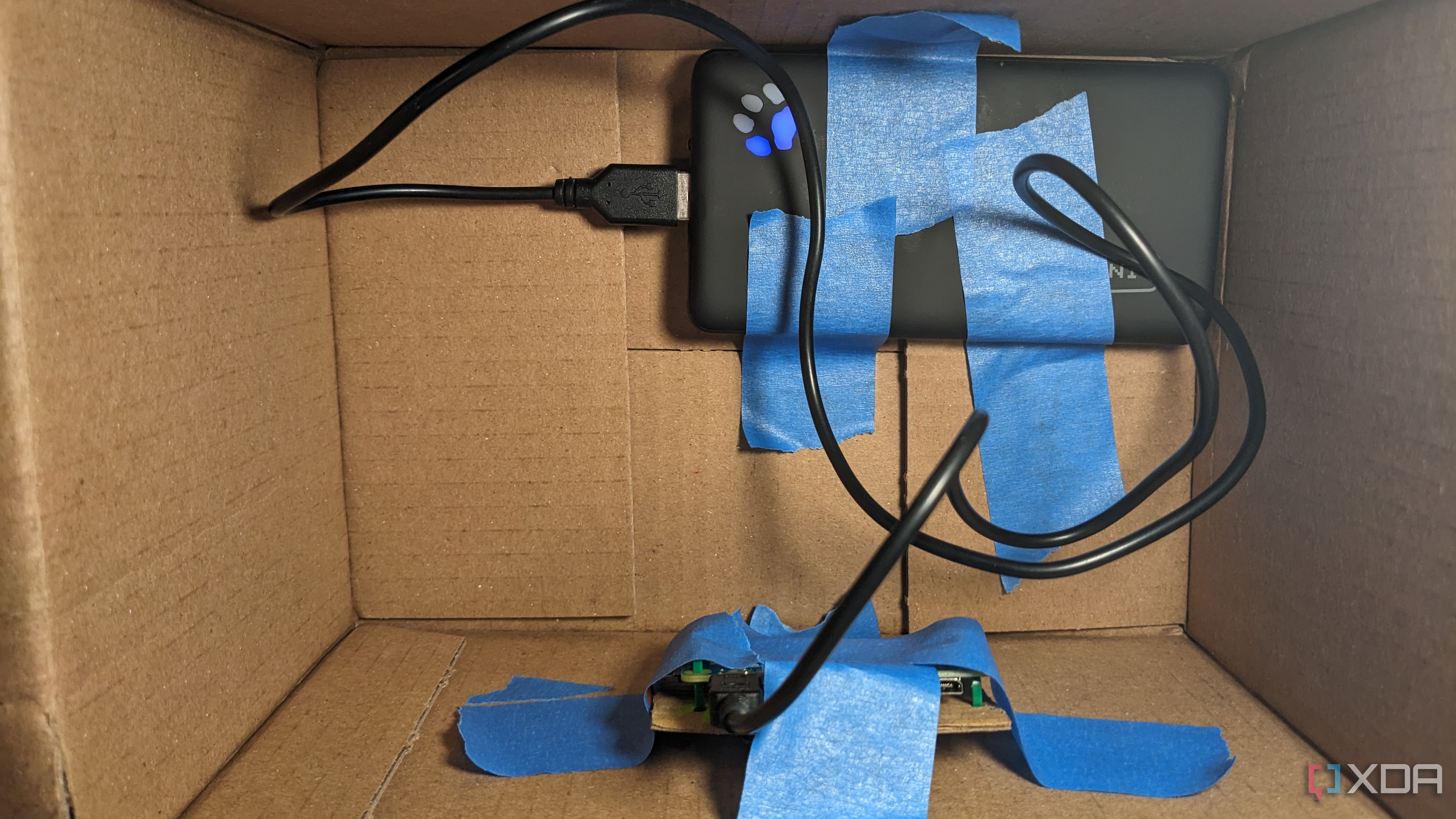 Raspberry Pi and power bank taped to inside of box