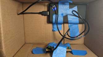 Raspberry Pi and power bank taped to inside of box