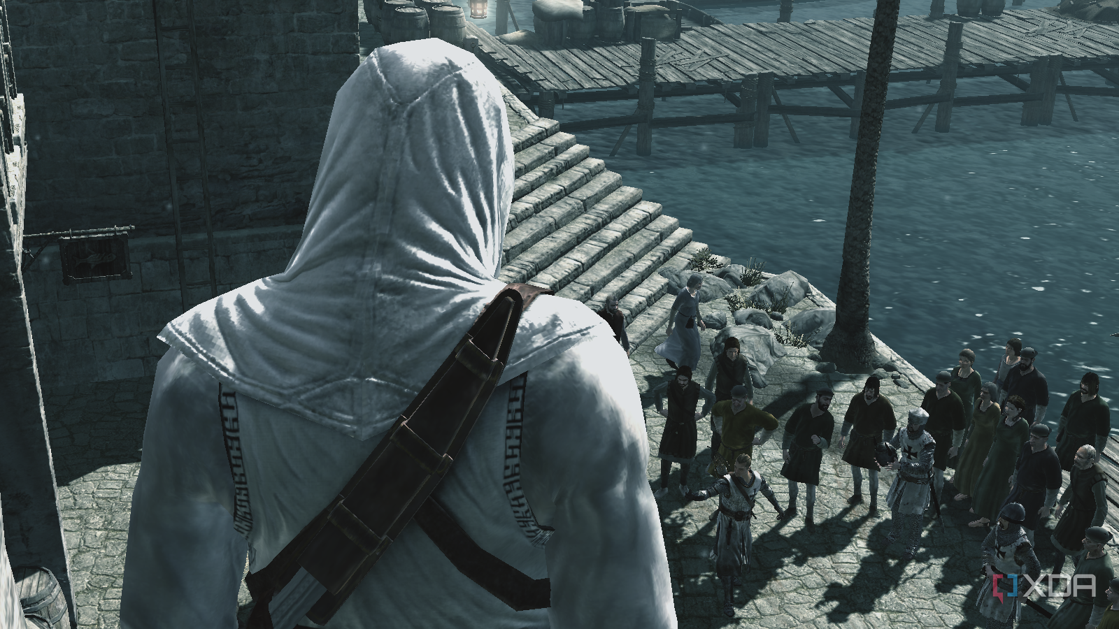 Altair looking at a crowd of civilians and a few Templar knights from the side of a building
