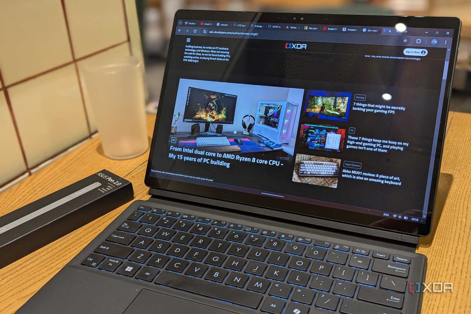A laptop on a wooden surface showing XDA website