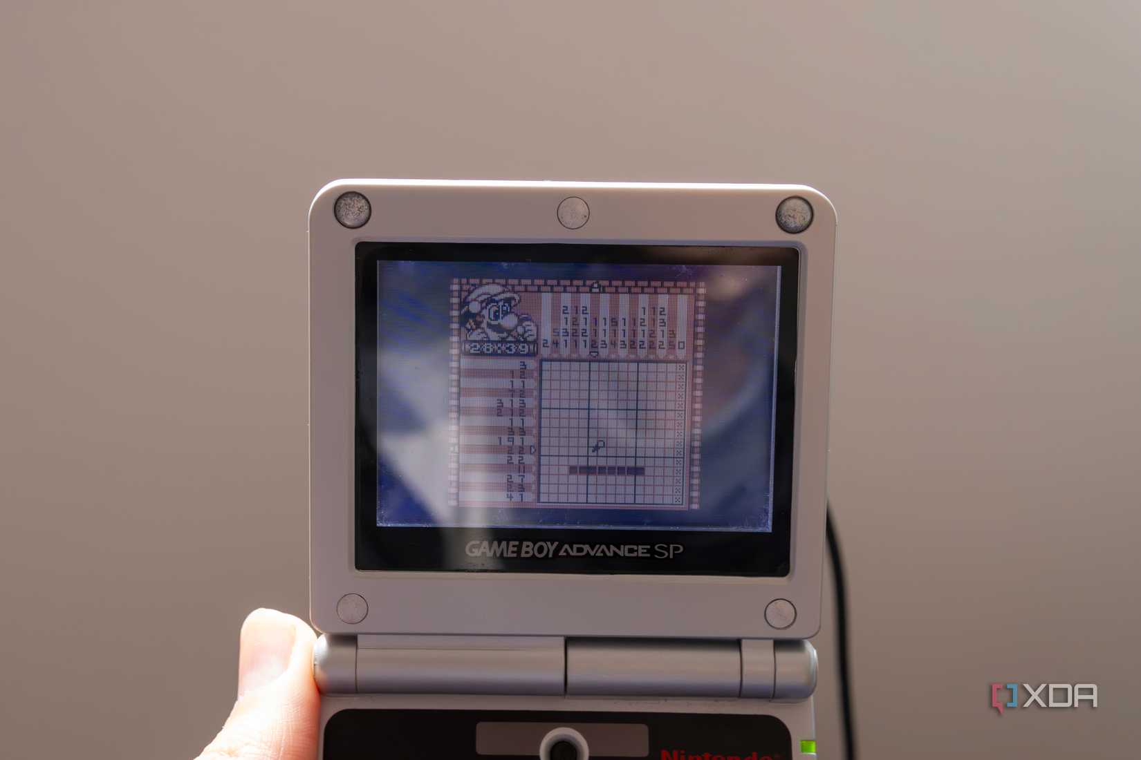 A Game Boy Advance SP playing the Game Boy game Mario's picross