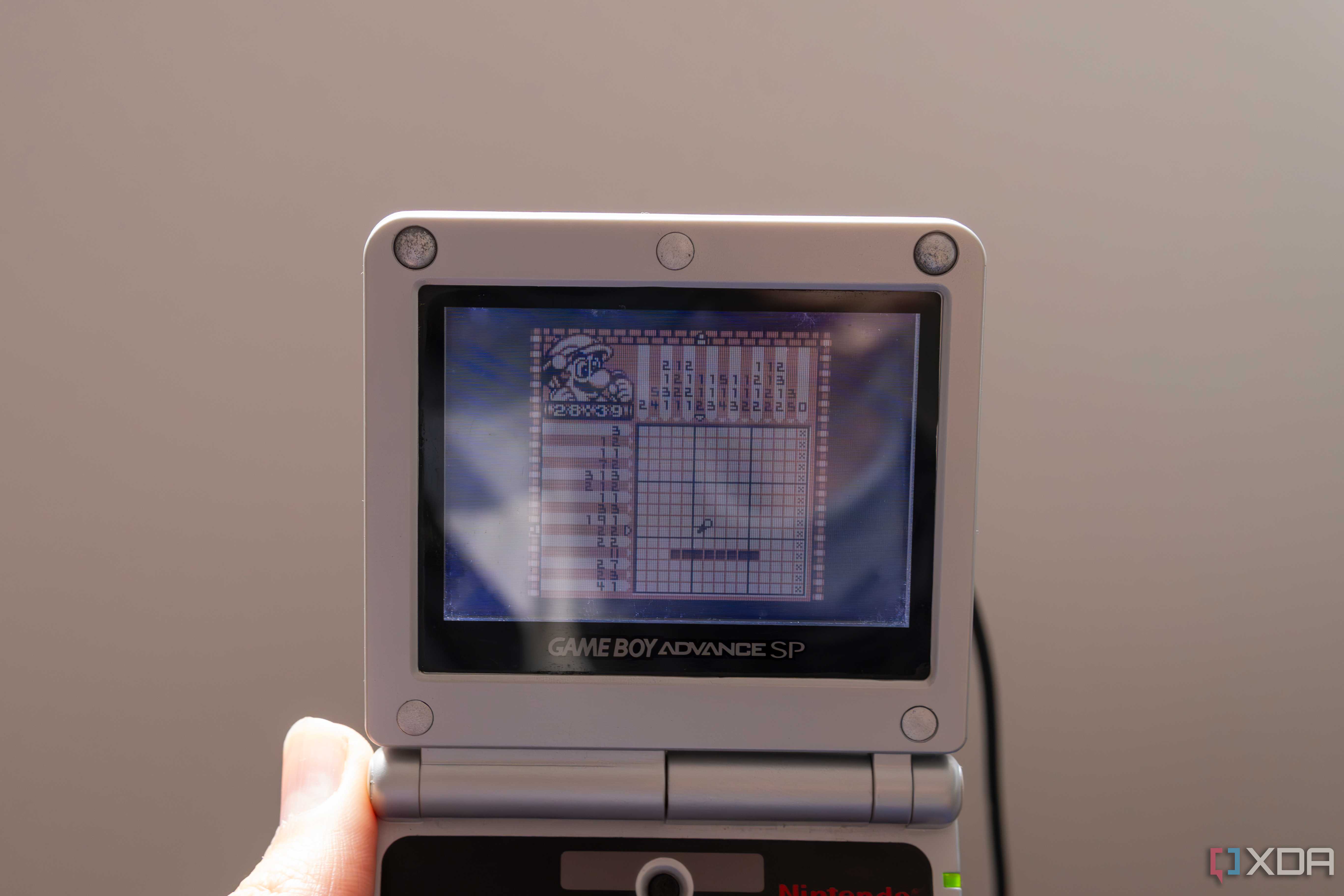 A Game Boy Advance SP playing the Game Boy game Mario's picross