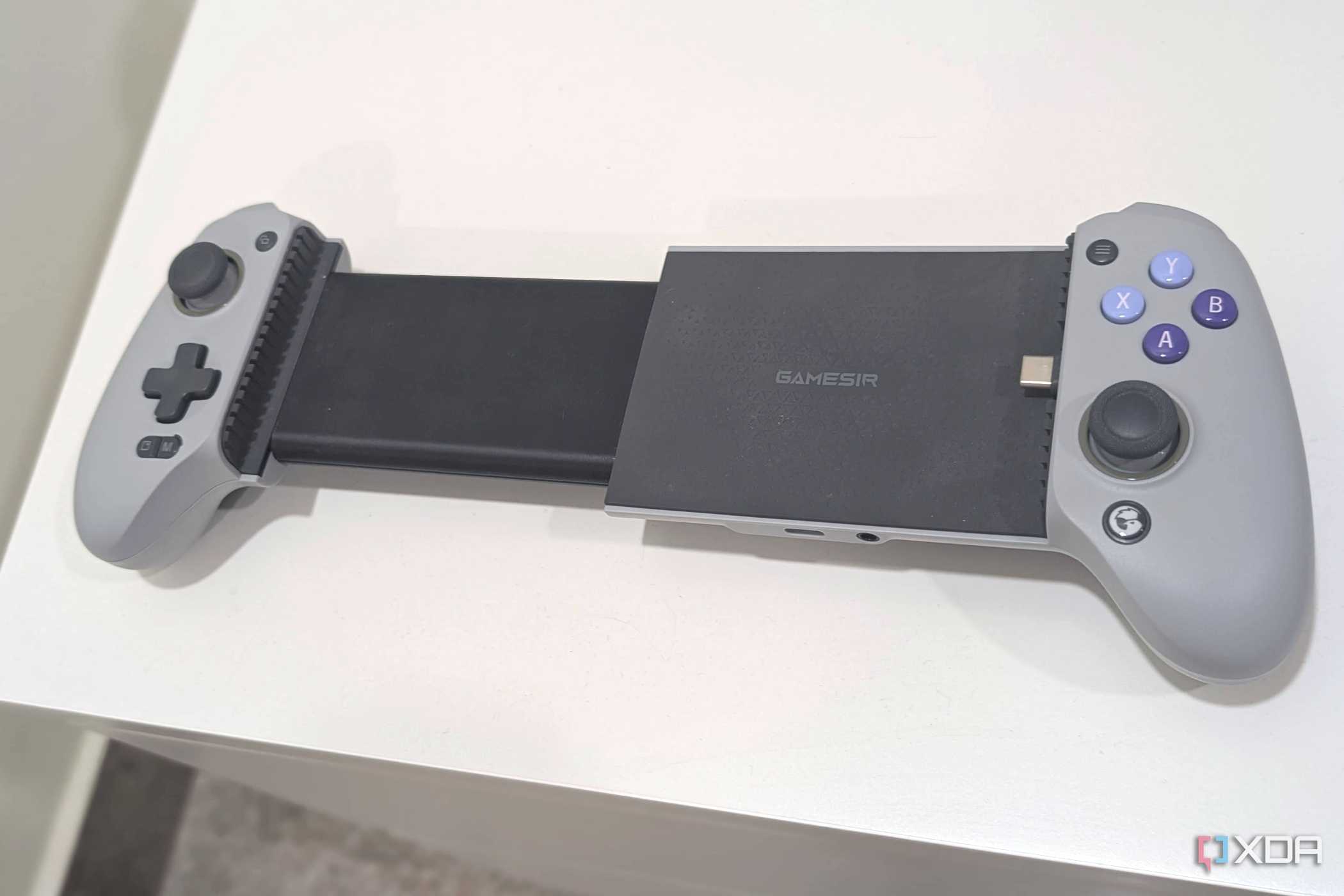 A grey Gamesir Galileo G8, extended, kept atop a white table.