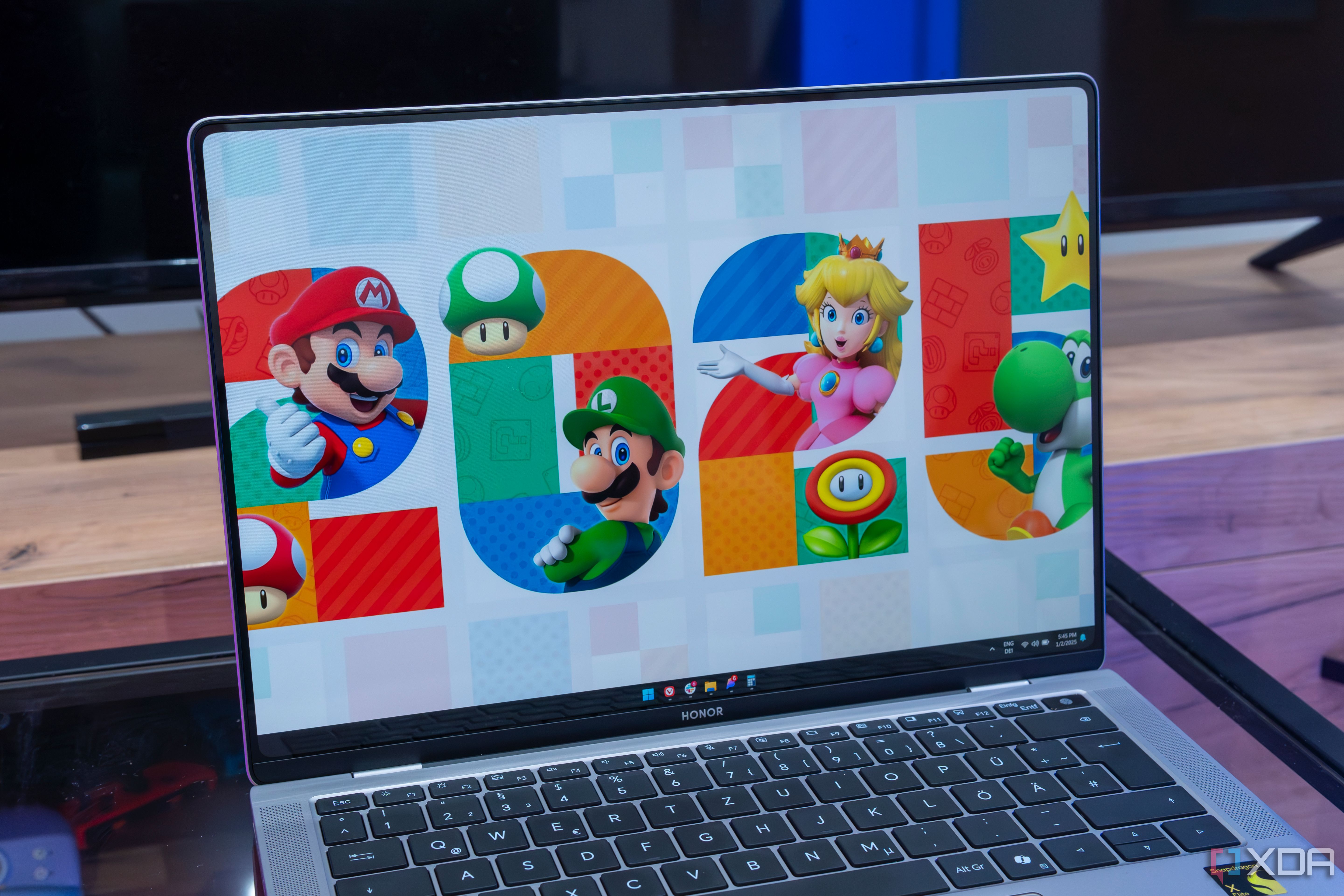 Angled view of the Honor MagicBook Art 14's display showing the Windows 11 desktop with a background showing the number 2025