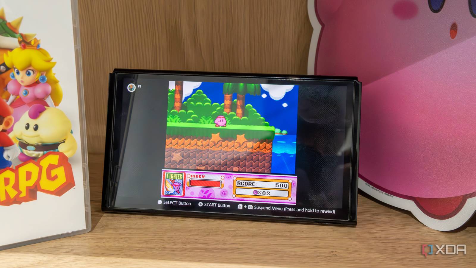 A Nintendo Switch OLED model with the Joy-Con detached playing Kirby Super Star on the SNES Switch Online app