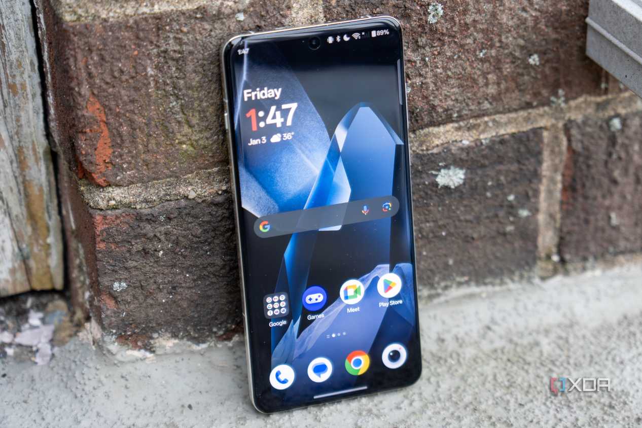 A OnePlus 13 standing up against a wall