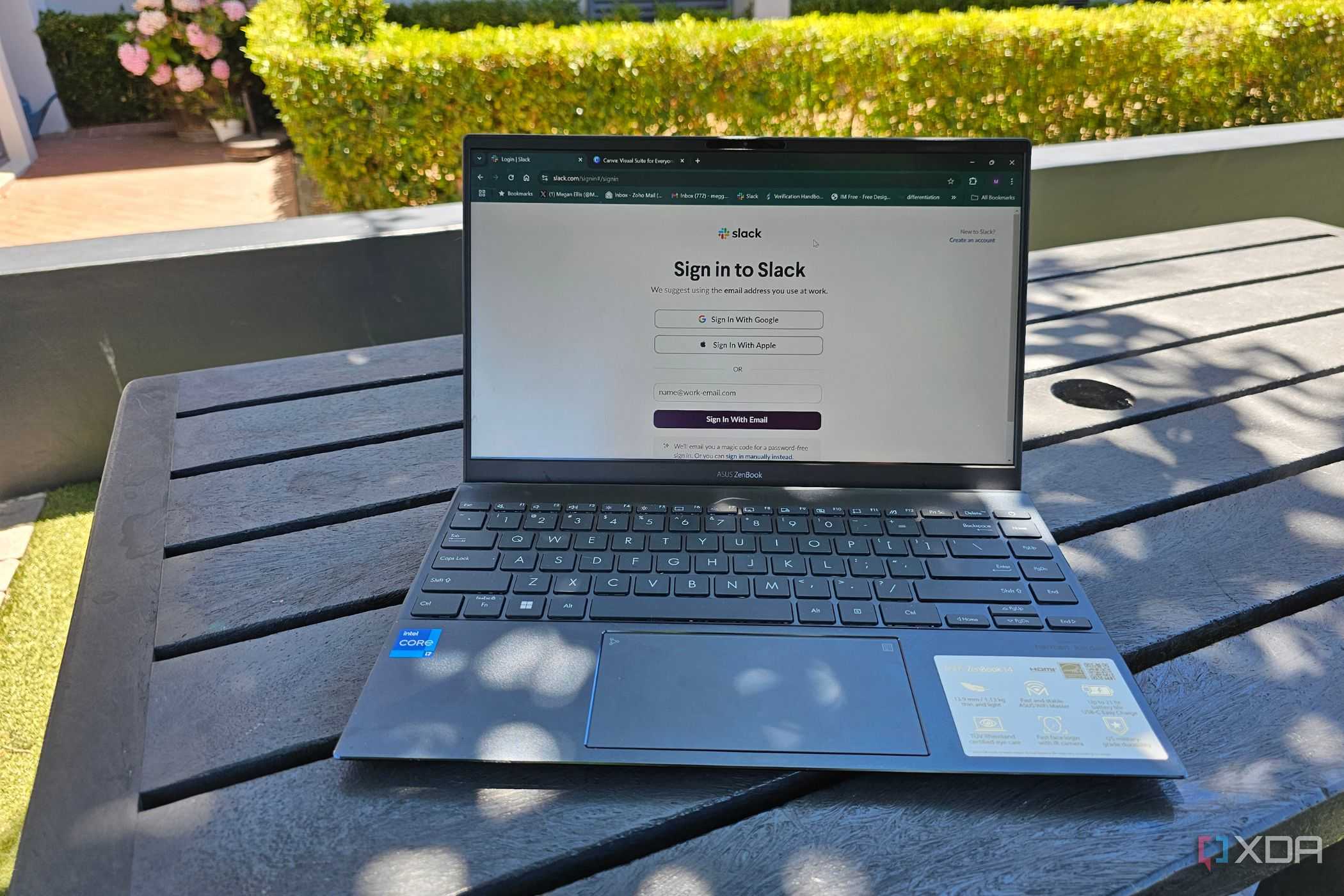 a laptop outside on a table showing a slack login screen