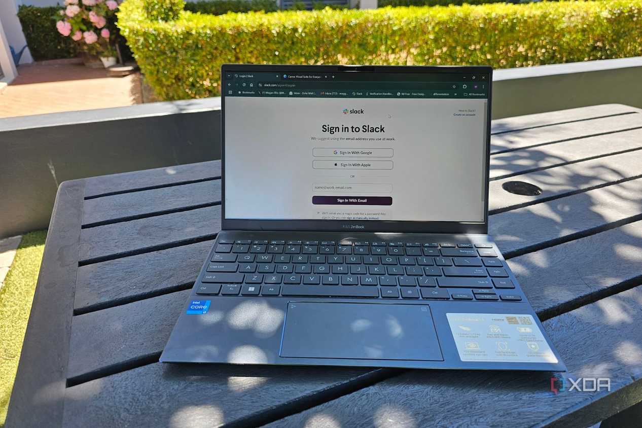 a laptop outside on a table showing a slack login screen