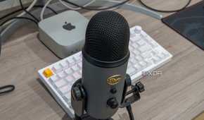 A Blue Yeti USB microphone in front a a Mac Mini and a keyboard