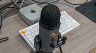 A Blue Yeti USB microphone in front a a Mac Mini and a keyboard
