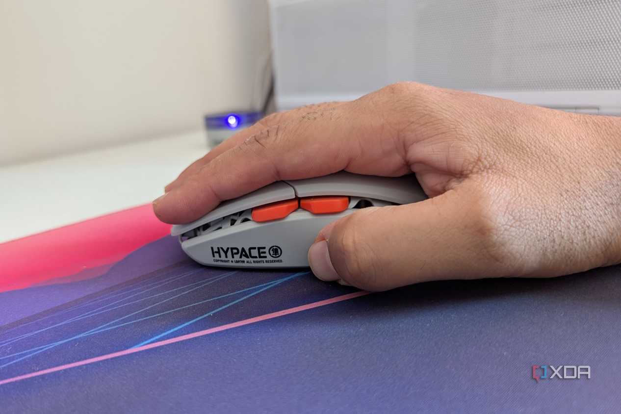 A person holding a gaming mouse in a palm grip