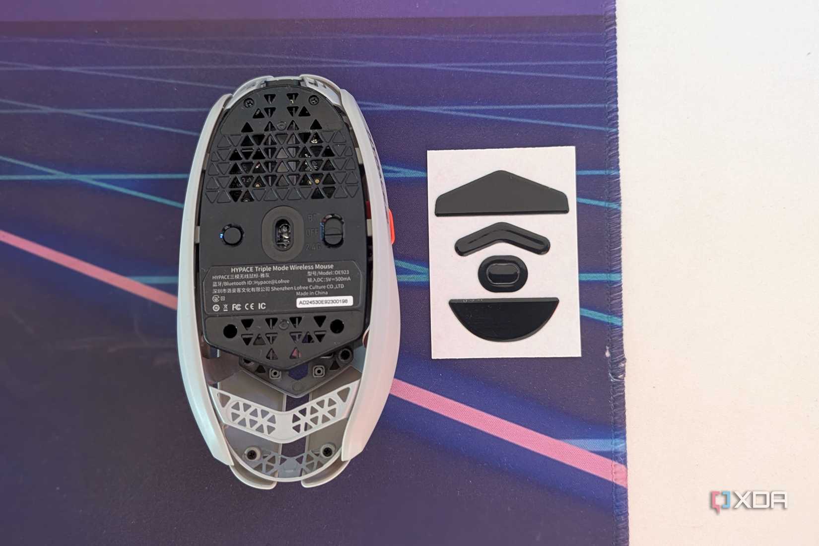 Вид снизу игровой мыши рядом с ее ножками на настольном коврике