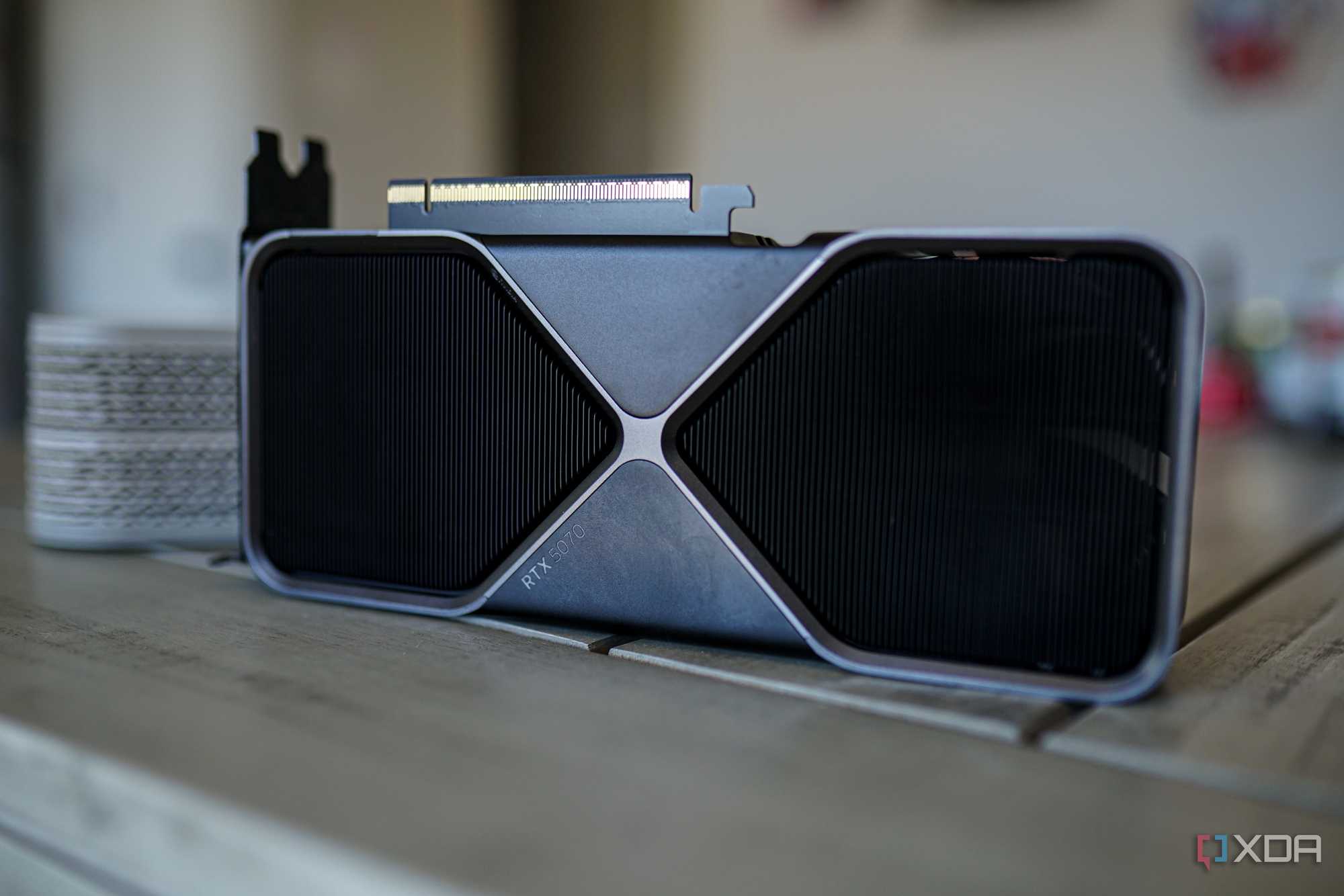 The RTX 5070 graphics card sitting on a table with the fans facing outward.