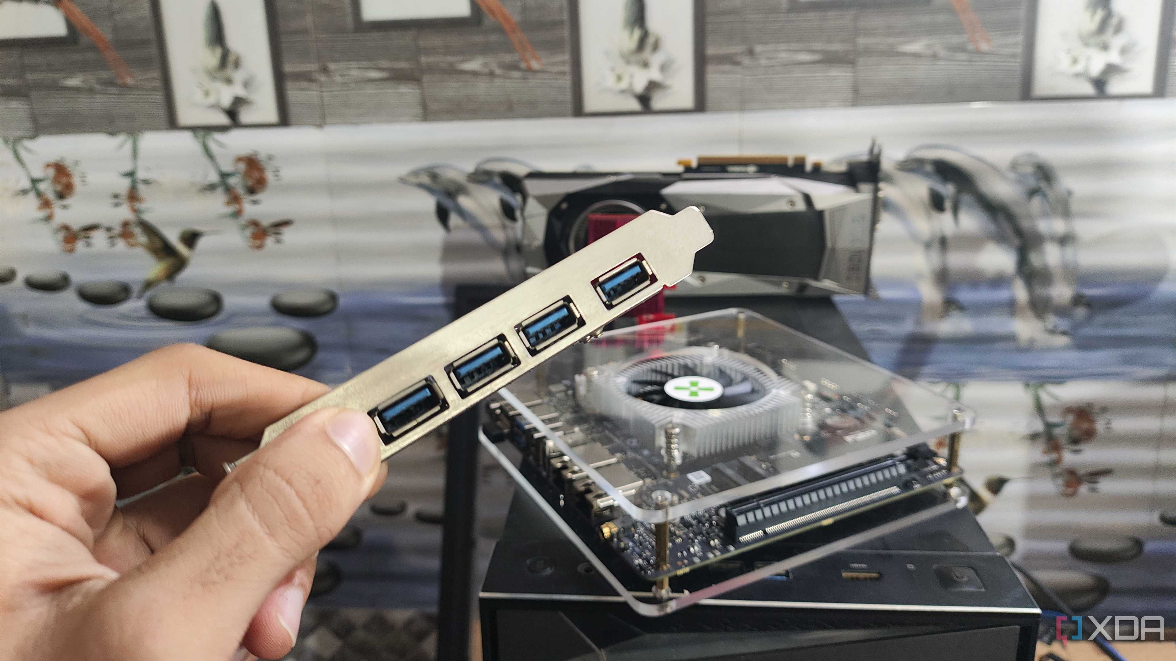 Holding a USB expansion card in front of the Radxa Orion O6