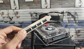 Holding a USB expansion card in front of the Radxa Orion O6