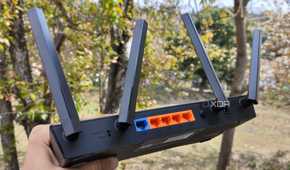 A person holding a TP-Link router