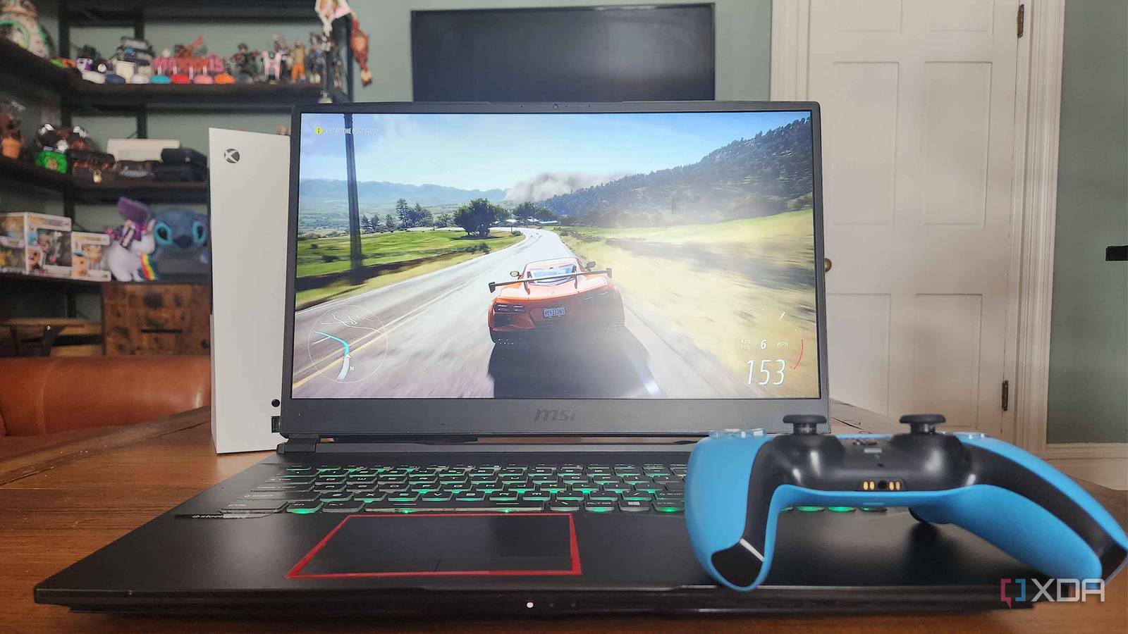 Xbox Series S, Laptop, and PlayStation Controller laying on table 