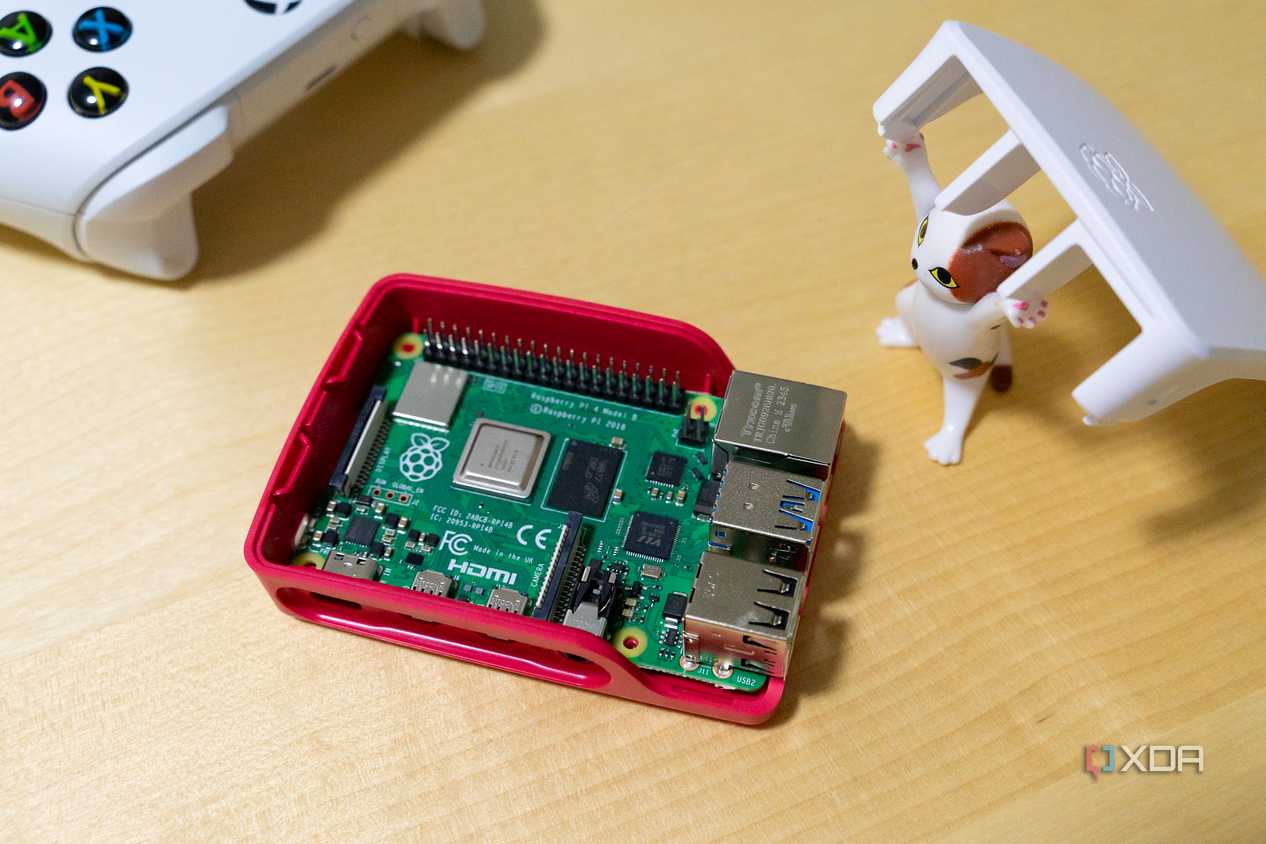 A toy cat figurine lifting the lid to expose the raspberry Pi inside a case.