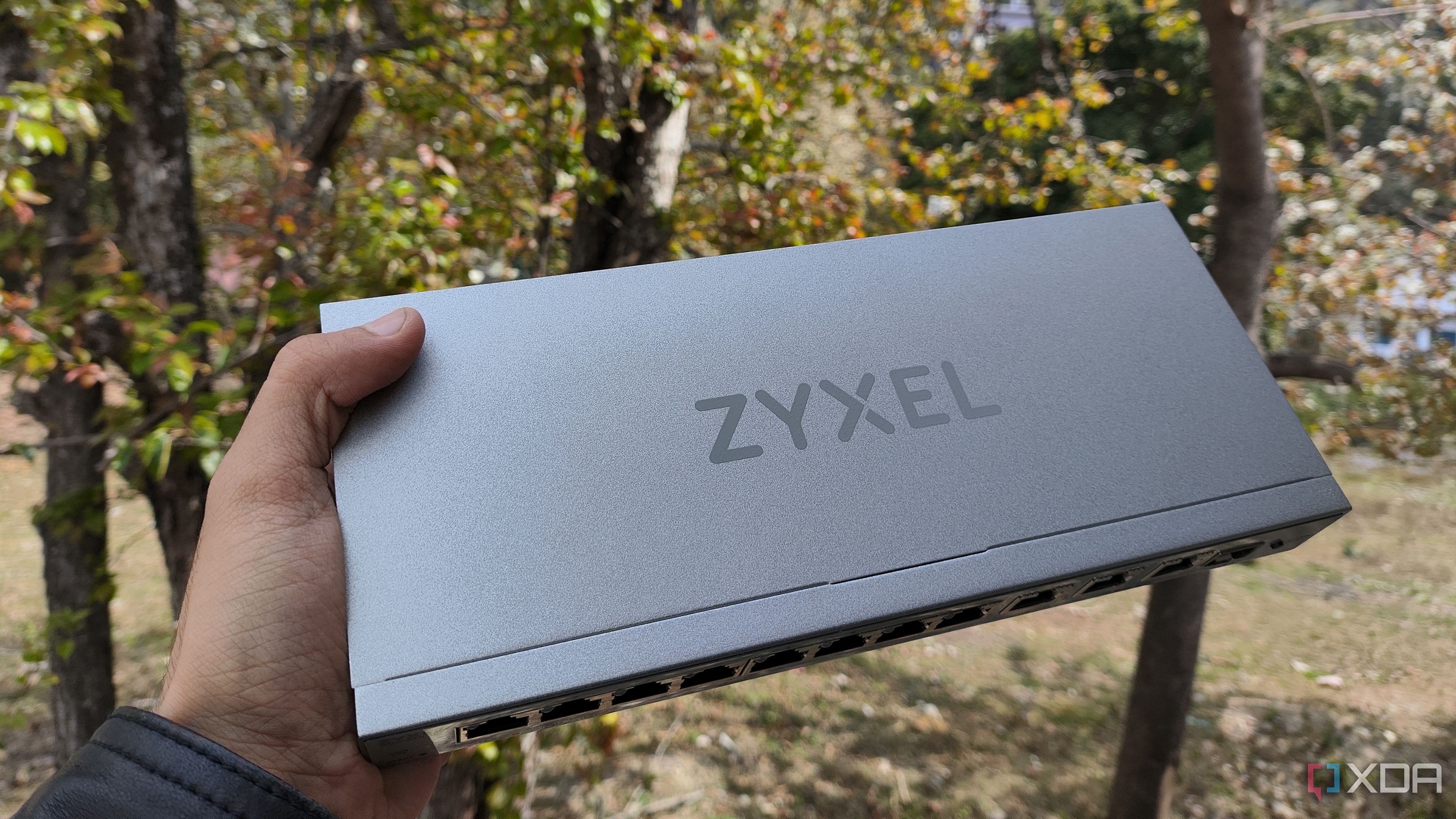 A person holding a Zyxel network switch