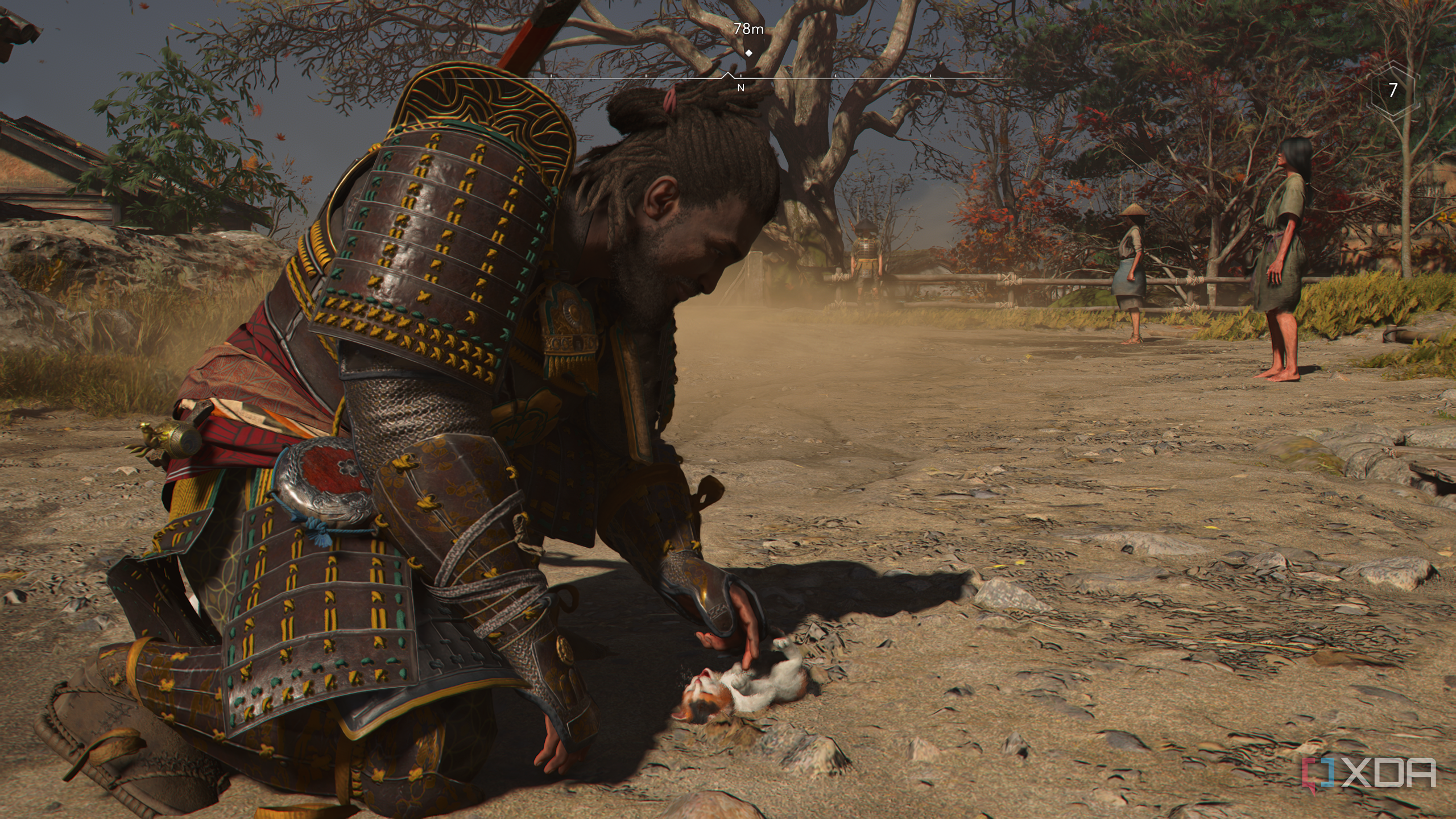 A screenshot from Assassin's Creed Shadows, showing Yasuke, the protagonist, playing with a kitten.